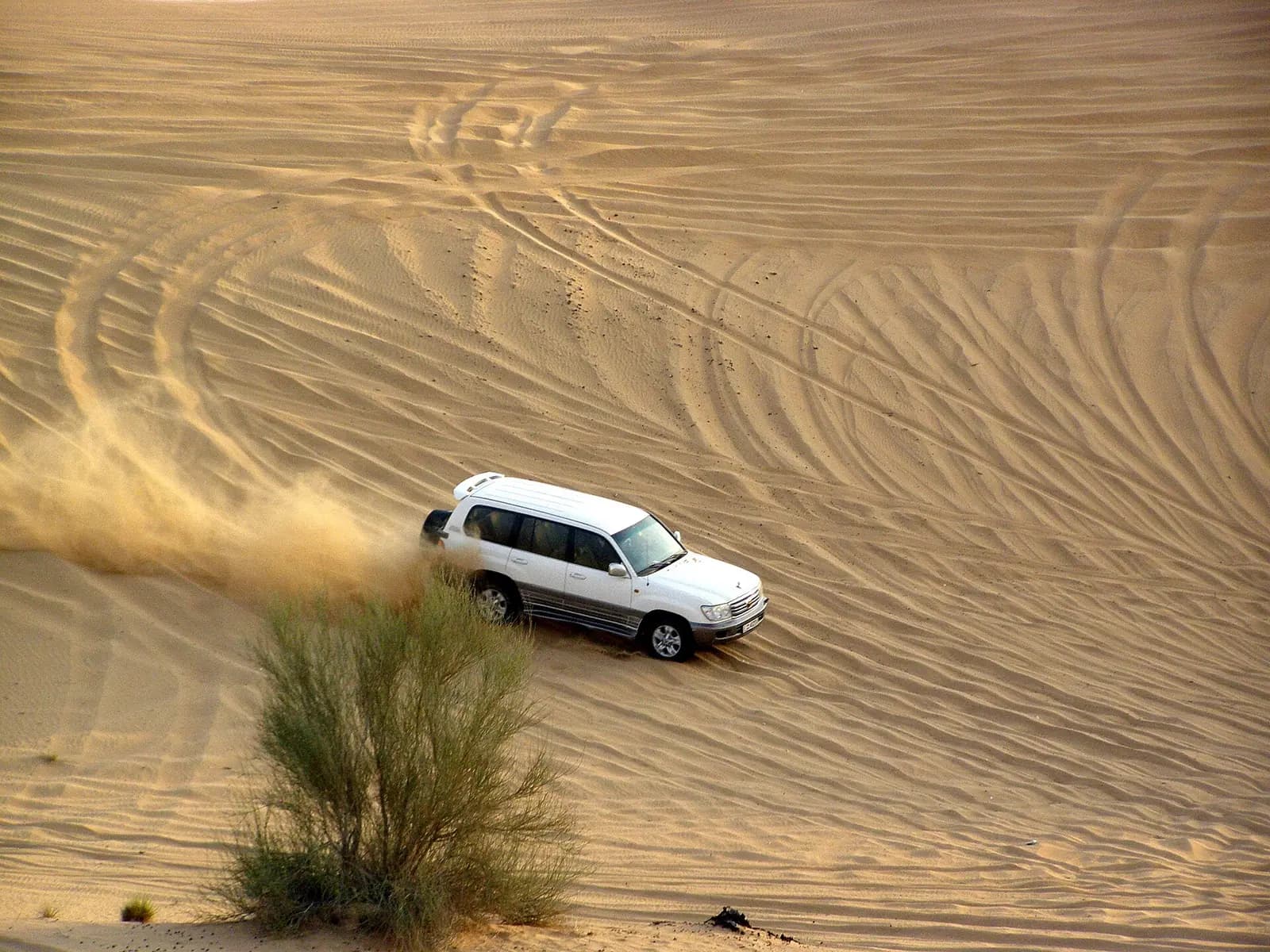 Four-wheel drives crossing the red dunes on a desert safari near Dubai