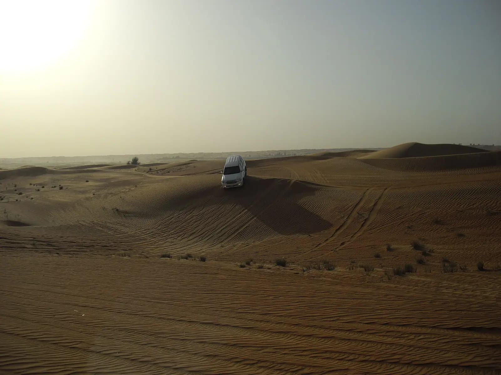 Vehicles on the red dunes of the desert outside Dubai
