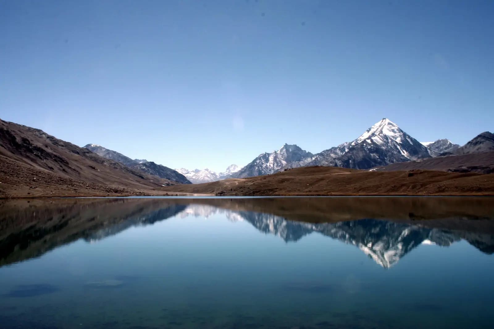 Snow peaks reflected in the still water of Chandratal lake, Himachal Pradesh