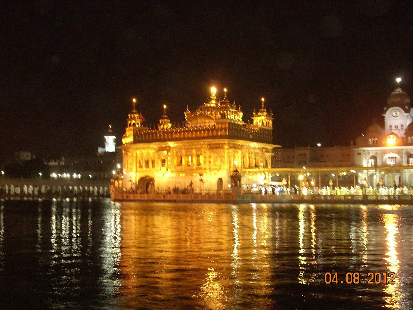 The Golden Temple lit and reflected in the Amrit Sarovar after dark, Amritsar